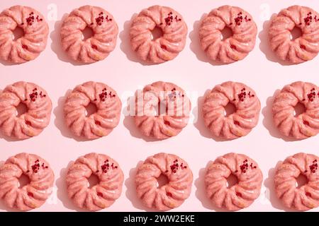Un motif de beignets sur un fond rose Banque D'Images