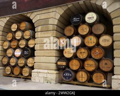 Une rangée de barils de différentes marques. Les barils sont empilés les uns sur les autres. Village viticole de Haro. Cave à vin. Espagne. Date 11-8-23 Banque D'Images