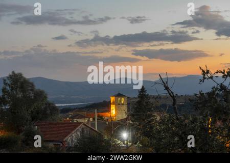 La nuit tombe à la périphérie du village de Braojos avec l'église de San Vicente Martir illuminée. Braojos Banque D'Images