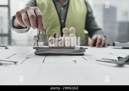 Modèle de maison, poupée en bois, clés et argent sur la disposition de la maison famille repersistante économiser de l'argent acheter maison et sécurité. Architecte et ingénieur concept. Banque D'Images