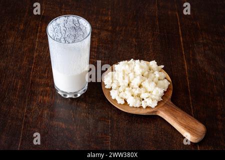 Grains de kéfir et boisson lactée fermentée isolés sur une table rustique en bois Banque D'Images