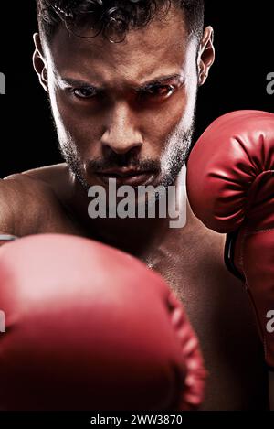 Portrait, gants de boxe et visage pour boxeur masculin, studio et athlète sur fond noir. Sombre, sport d'entraînement et de combat ou MMA pour modèle homme Banque D'Images