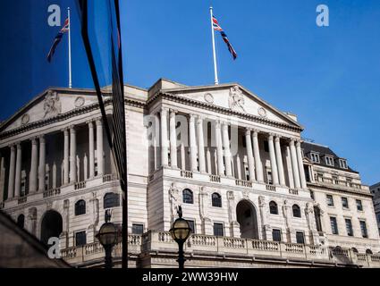 Londres, Royaume-Uni. 21 mars 2024. Bank of England dans la City de Londres reflété dans une fenêtre d'un bus qui passe. La Banque d'Angleterre annoncera le 21 mars une décision de taux d'intérêt qui devrait se maintenir à 5,25 % malgré une baisse de l'inflation. L'inflation britannique est tombée à 3,4 pour cent, le plus bas depuis septembre 2021 crédit : Mark Thomas/Alamy Live News Banque D'Images