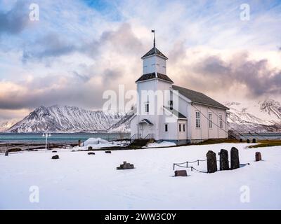 Église de Gimsoy avec cimetière, montagnes enneigées en arrière-plan, hiver, Gimsoya, Lofoten, Norvège Banque D'Images