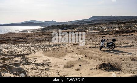 Scooter garé sur la côte près de Sarakinikoer, Milos, Cyclades, Grèce Banque D'Images