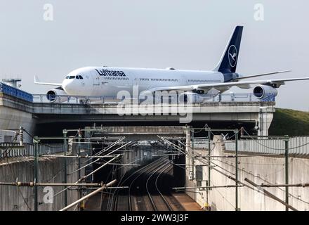 Un Airbus A340-300 de Lufthansa portant le nom de la ville de Dorsten traverse un pont ferroviaire à l'aéroport de Francfort, le 15/03/2024 Banque D'Images