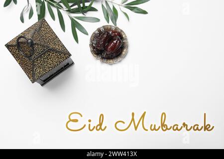 Carte de voeux Eid Moubarak. Lanterne arabe et dattes sur table blanche, pose à plat Banque D'Images