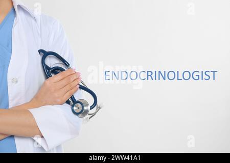 Endocrinologue avec stéthoscope sur fond gris clair, gros plan Banque D'Images