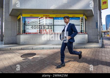 Tokyo, Japon. 21 mars 2024. Les membres du public passent devant une exposition montrant le Nikkei Stock Average dans le quartier financier de Tokyo. Crédit : Marcin Nowak/Alamy Live News Banque D'Images