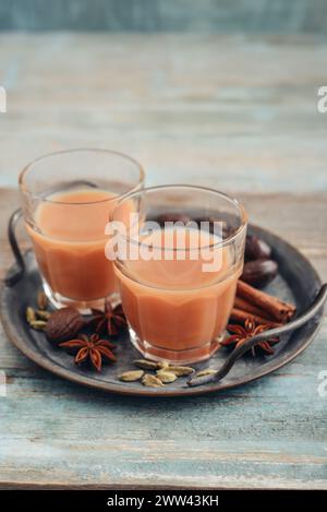 Boisson indienne traditionnelle - thé masala avec des épices sur plateau en métal sur fond en bois Banque D'Images