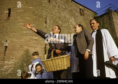 Festival annuel de lancement de fromage au pain à l'église St Mary's St Briavels Gloucestershire Angleterre. Forestier Keith Creswick, et son fils Gerald. Vicaire de l'église debout sur le mur de l'église dans la forêt de Dean. ANNÉES 1970 ROYAUME-UNI HOMER SYKES Banque D'Images