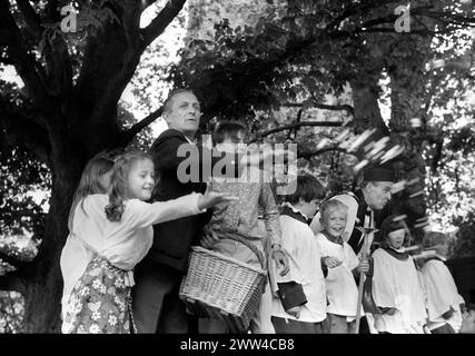 Festival annuel de lancement de fromage de pain à l'église St Mary's St Briavels Gloucestershire England.1971 Forester Keith Creswick, et son fils Gerald. Chorale garçons et filles avec le vicaire de l'église. Tous debout sur le mur de l'église dans la forêt de Dean 1970s UK HOMER SYKES Banque D'Images