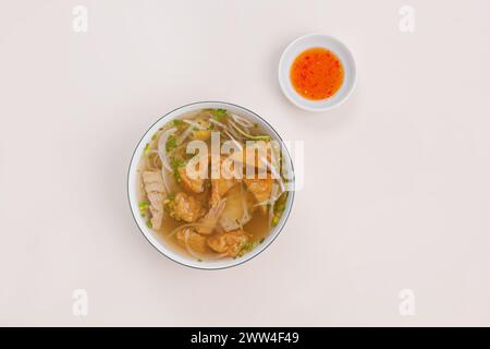 Banh canh cha Ca Nha Trang, soupe de nouilles de riz avec gâteau de poisson de Nha Trang, nourriture vietnamienne isolée sur fond blanc, vue de dessus Banque D'Images