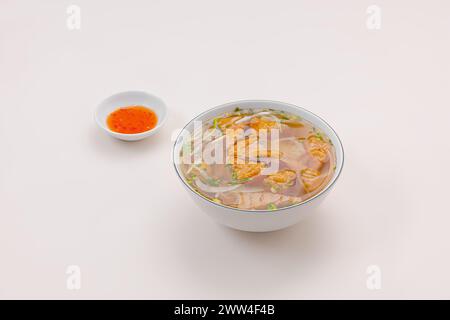 Banh canh cha Ca Nha Trang, soupe de nouilles de riz avec gâteau de poisson de Nha Trang, nourriture vietnamienne isolée sur fond blanc, vue en perspective Banque D'Images