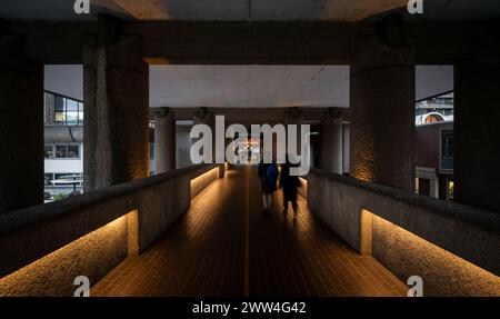 Londres, Royaume-Uni : passerelle de haut niveau sur le domaine Barbican dans la ville de Londres menant au Barbican Centre. Avec les gens marchant. Banque D'Images