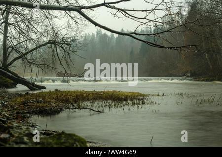 Dans l’étreinte douce d’une longue exposition, ABAVA Waterfall révèle sa danse envoûtante, une symphonie de mouvement figée dans le temps. Paysage serein de Lettonie Banque D'Images