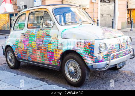 Genova, Italie - 6 août 2023 : voiture Fiat 500 vintage peinte avec paysage urbain traditionnel de la région Ligurie - destination de voyage Italie Banque D'Images