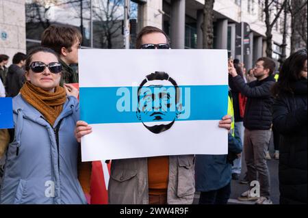 17.03.2024, Berlin, Deutschland, Europa - Tausende Menschen protestieren vor der Russischen Botschaft Unter den Linden im Berliner Bezirk Mitte unter dem Titel Schluss mit Poutine, mit Krieg, Luege und Repressionen gegen den russischen Praesidenten Poutine und gegen den Angriffskrieg auf die Ukraine, waehrend zeitgleich in Russland der letzte Tag der Praesidentschaftswahl stattfindet. In dieser Aufnahme haelt ein Teilnehmer ein Protestplakat mit dem Abbild des verstorbenen russischen Oppositionsfuehrers Alexei Nawalny. *** 17 03 2024, Berlin, Allemagne, Europe des milliers de personnes manifestent devant Banque D'Images