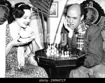 L'actrice britannique JESSIE MATTHEWS et l'acteur comique ALASTAIR SIM jouant aux échecs entre les scènes lors de la réalisation de l'ESCALADE 1938 réalisatrice CAROL REED Dresses par NORMAN HARTNELL Gaumont British Banque D'Images
