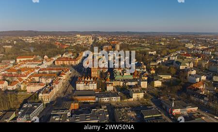 Un drone capture le centre-ville de Koszalin baigné de lumière dorée, avec la cathédrale, Victory Street et l'hôtel de ville. Banque D'Images