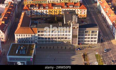 Un drone capture le centre-ville de Koszalin baigné de lumière dorée, avec la cathédrale, Victory Street et l'hôtel de ville. Banque D'Images