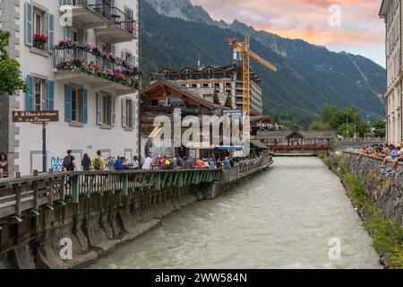 Café en plein air surplombant la rivière Arve bondé de gens à l'heure de l'apéritif du soir dans le centre de Chamonix, haute Savoie, France Banque D'Images