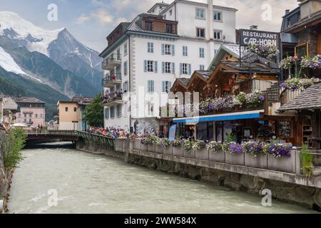 Café en plein air surplombant la rivière Arve bondé de gens à l'heure de l'apéritif du soir dans le centre de Chamonix, haute Savoie, France Banque D'Images