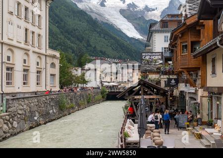 Café en plein air surplombant la rivière Arve bondé de gens à l'heure de l'apéritif du soir dans le centre de Chamonix, haute Savoie, France Banque D'Images