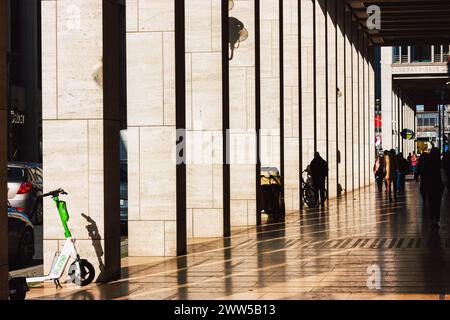 Berlin, Allemagne. 3 octobre 2023 Corridor, passage avec colonnes en perspective. Citadins, citadins. Trottoir du matin avec scooter garé. Banque D'Images