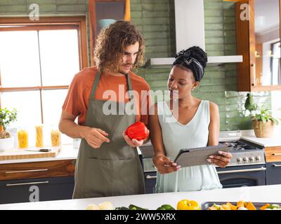 Un couple diversifié cuisine ensemble dans une cuisine moderne Banque D'Images