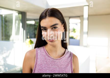 Une jeune femme brune caucasienne se tient souriante à la maison Banque D'Images
