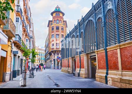 Rue Calle Sagasta avec un mur du marché Atarazanas et façade du bâtiment Guerrero Strachan, Malaga, Espagne Banque D'Images
