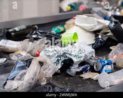 Déchets plastiques sur une bande transporteuse dans une usine de gestion des déchets Banque D'Images