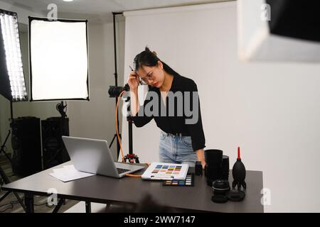 Photographe frustrée travaillant dans son studio Banque D'Images