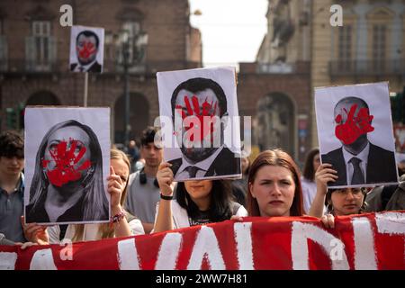 Torino, Italie. 21 mars 2024. Des étudiants brandissent des pancartes avec les visages de Meloni, Salvini et Valditara, avec de la peinture rouge lors d'une manifestation d'étudiants à l'échelle nationale pour protester contre le gouvernement, la réforme de l'école, la violence policière et le génocide en Palestine à Turin, dans le nord-ouest de l'Italie - vendredi 22 mars 2024. Actualités (photo de Marco Alpozzi/Lapresse) crédit : LaPresse/Alamy Live News Banque D'Images