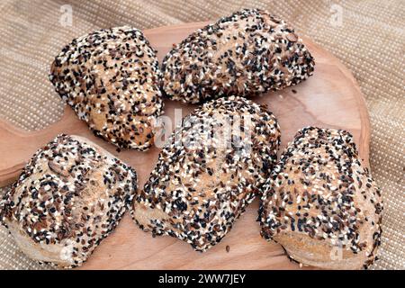 Plusieurs petits pains, cuits à la maison au four et saupoudrés de graines de lin, de graines de sésame et de cumin. Banque D'Images