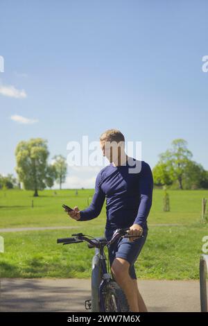 Homme mûr en parc avec location d'écouter de la musique sur le smartphone. Banque D'Images