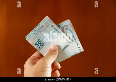 Détail de la main avec plusieurs billets d'argent utilisés au Brésil - plusieurs centaines de reais en billets Banque D'Images