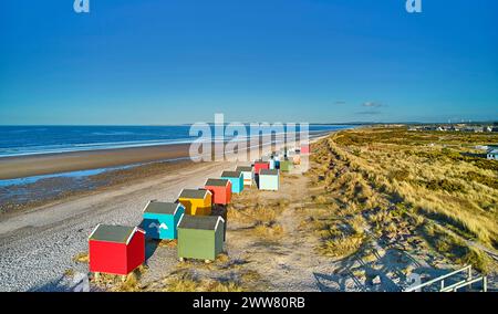 Findhorn Moray Coast Scotland une rangée de cabanes de plage colorées surplombant la plage de sable et la mer bleue Banque D'Images