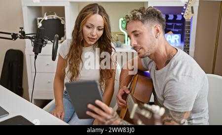 Un homme et une femme collaborent en tant que chanteurs dans un studio de musique, axé sur la composition et l'enregistrement. Banque D'Images