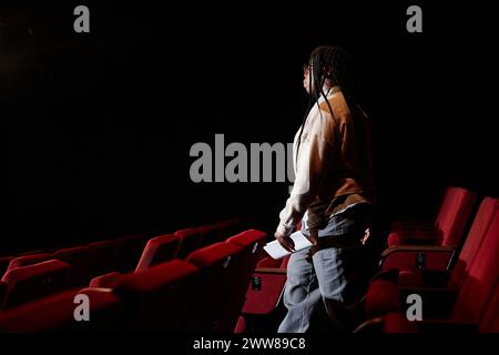 Portrait de vue de côté d'une femme afro-américaine marchant vers le bas à la scène dans l'espace vide de copie de théâtre Banque D'Images