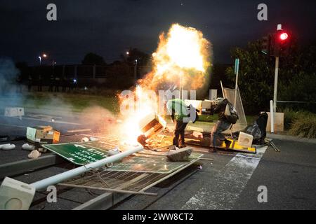 22 mars 2024, Melbourne, Australie. Deux manifestants, en plus d'un groupe d'activistes pro-palestiniens autonomes qui font du piquetage sur un porte-conteneurs affilé par Israël, sont frappés de coups de feu alors qu'ils tentent d'alimenter un incendie sur une barricade créée par les piqueurs pour ralentir l'avancée de la police anti-émeute. Crédit : Jay Kogler/Alamy Live News Banque D'Images