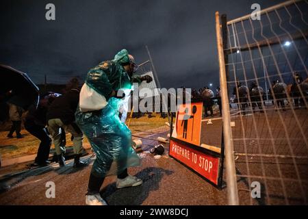 22 mars 2024, Melbourne, Australie. Des manifestants, en dehors d'un groupe d'activistes pro-palestiniens autonomes qui font du piquetage sur un porte-conteneurs affilé par Israël, dressent des barricades de fortune contre la police anti-émeute qui tente de disperser la foule. Crédit : Jay Kogler/Alamy Live News Banque D'Images