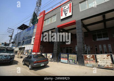 Les policiers sont en état d'alerte pour éviter un incident fâcheux devant la succursale du restaurant Kentucky Fried Chicken (KFC) après sa fermeture temporaire suite à une manifestation de solidarité avec le peuple palestinien, à Peshawar le vendredi 22 mars 2024. Banque D'Images