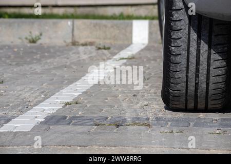 Vue rapprochée d'un pneu arrière plat sur une voiture. Détail du pneu à plat de roue de voiture sur la route, parking. Fond de pneu éclaté. Assurance automobile et route Banque D'Images