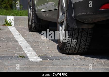 Vue rapprochée d'un pneu arrière plat sur une voiture. Détail du pneu à plat de roue de voiture sur la route, parking. Fond de pneu éclaté. Assurance automobile et route Banque D'Images