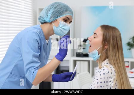 Tests en laboratoire. Médecin prélevant un échantillon de la bouche du patient avec un coton-tige à l'hôpital Banque D'Images