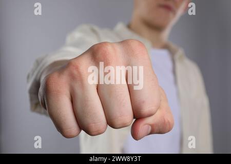 Homme montrant poing avec espace pour tatouage sur fond gris, mise au point sélective Banque D'Images