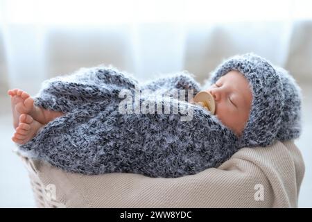 Mignon bébé nouveau-né de dormir dans le panier à la maison Banque D'Images