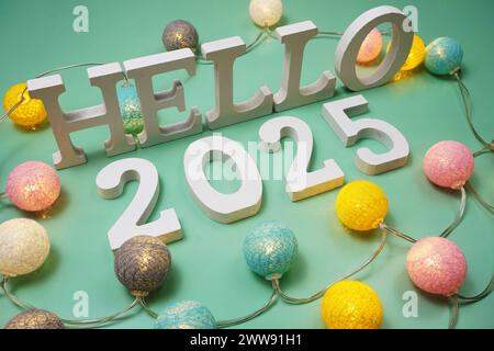 Lettre de l'alphabet Hello 2025 avec des boules de coton LED sur fond vert Banque D'Images